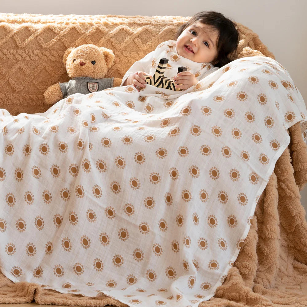 Bébé allongé et couvert d'un lange en mousseline