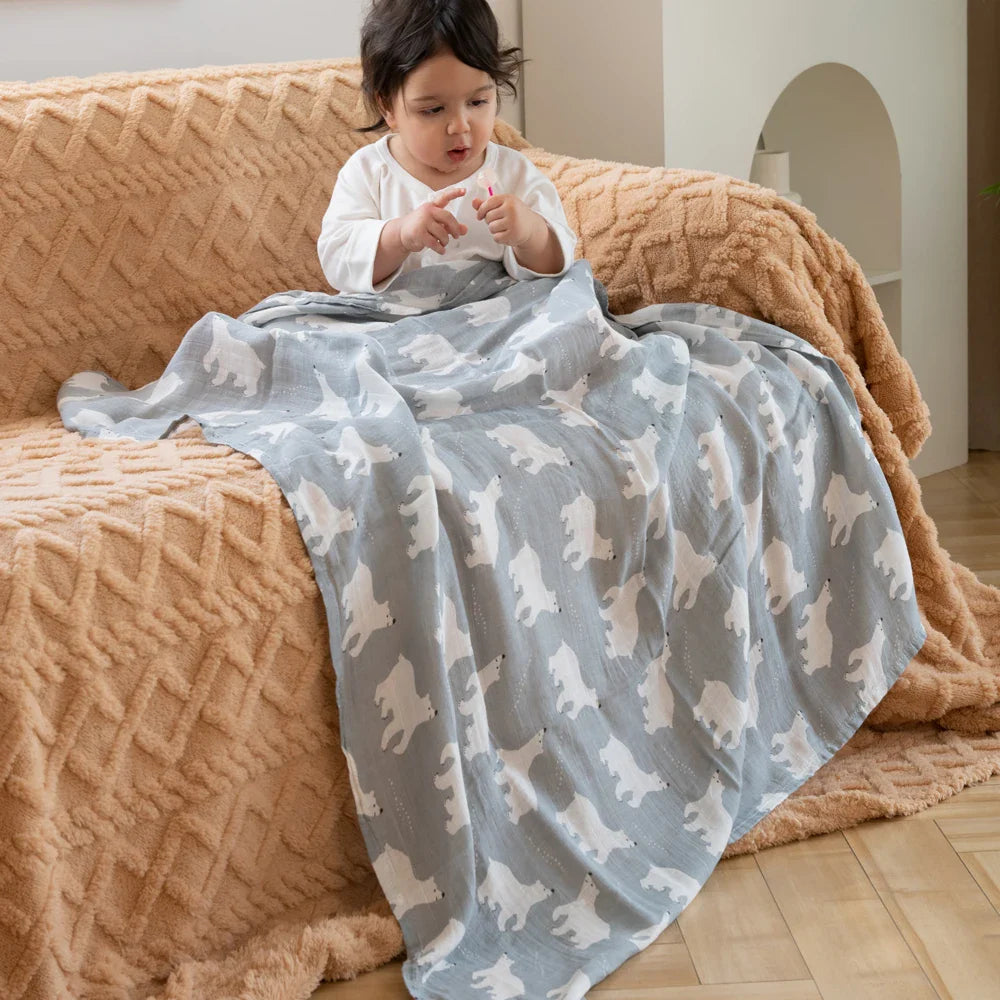 Bébé assis et couvert d'un lange en mousseline