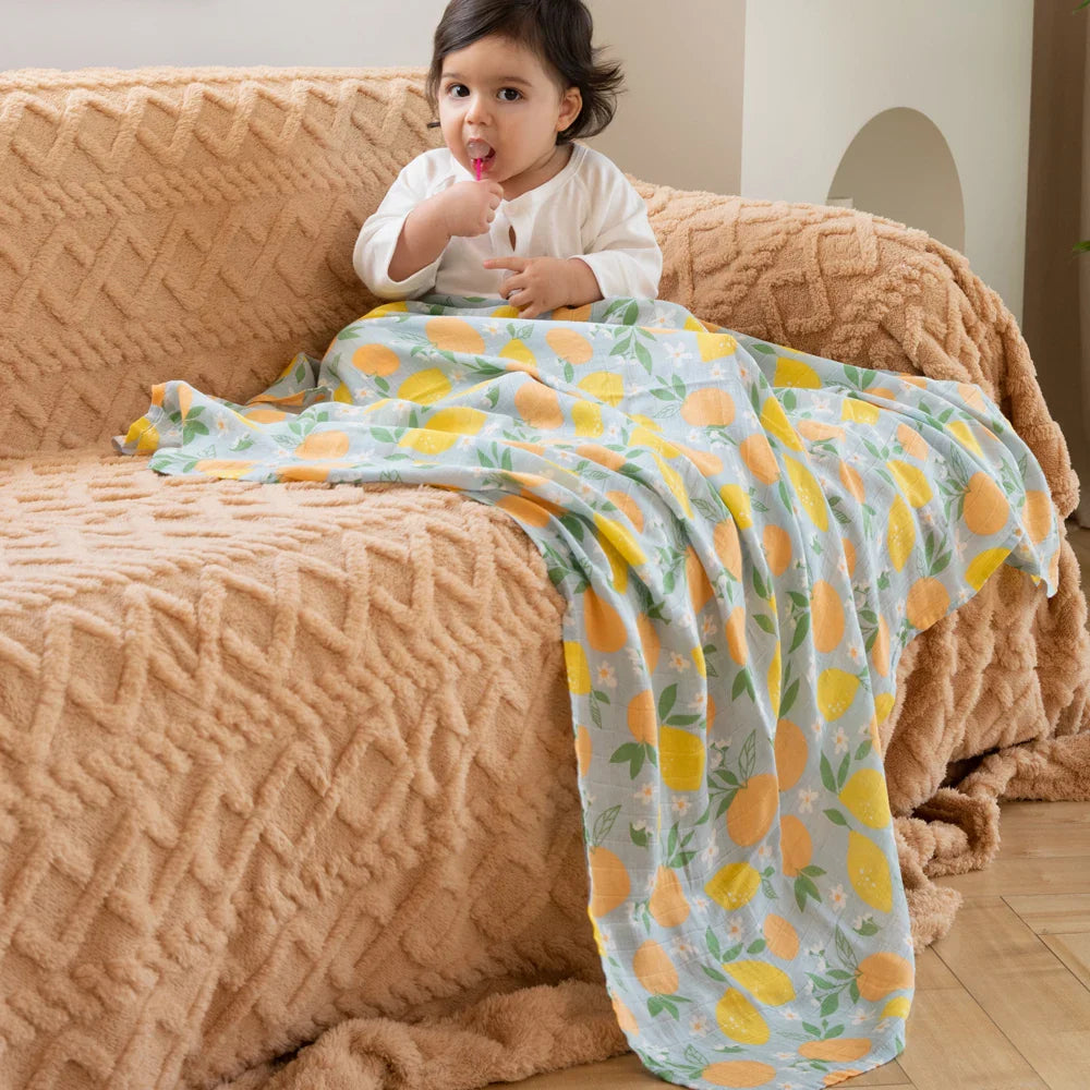 Bébé assis et couvert d'un lange en mousseline