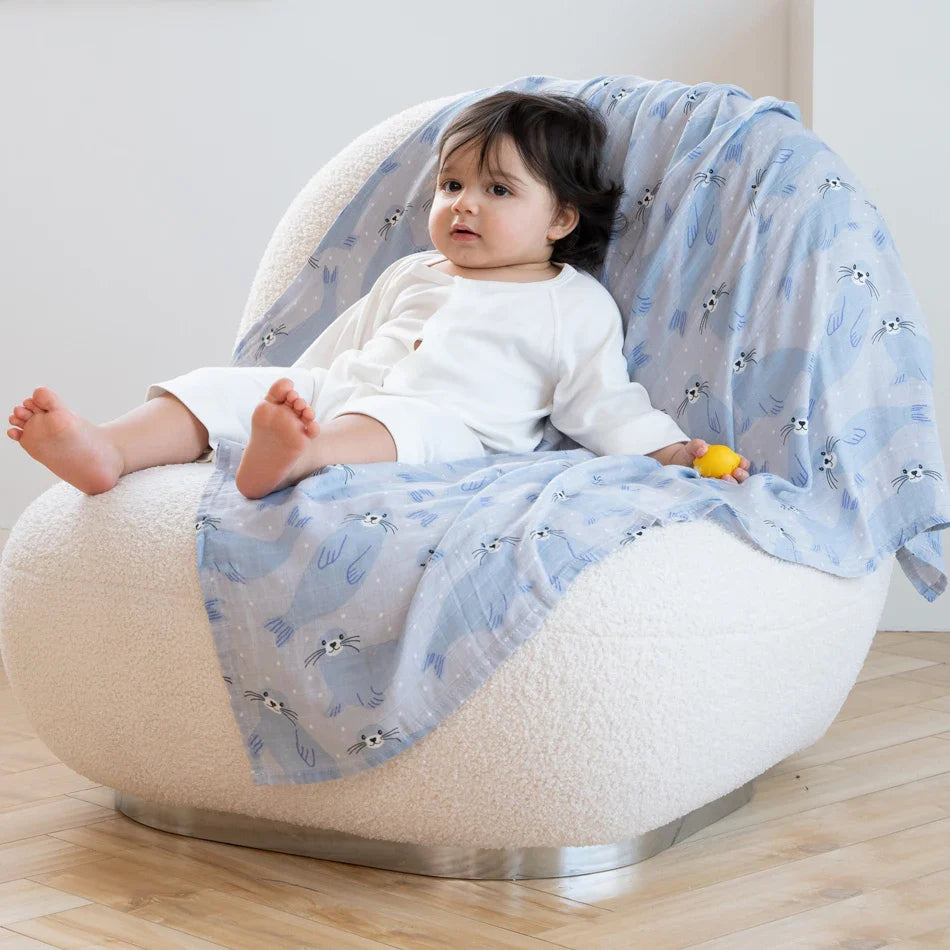 Bébé assis sur un lange en mousseline