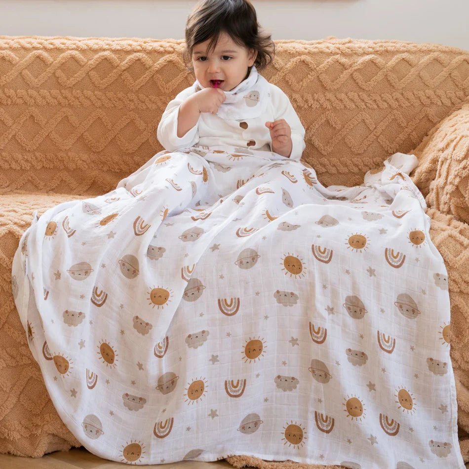 Bébé assis et couvert d'un lange en mousseline